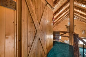 A wooden interior with a sloped ceiling, a fire extinguisher mounted on the wall, and a wooden beam structure. - 2 Elks Cabin with Private Hot Tub | Ski Wolf Creek (South Fork)