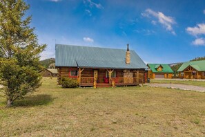 A rustic log cabin with a porch, a chimney, and a green roof. - 2 Elks Cabin with Private Hot Tub | Ski Wolf Creek (South Fork)