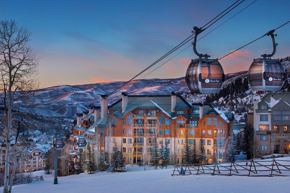 Une station de ski dotée d'un grand chalet et de deux télésièges.