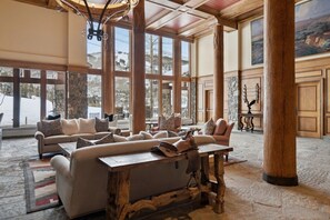 A spacious lobby with a large sofa set, wooden tables, and stone pillars. - BC Slopeside Ski Studio, Hot Tub, Resort Amenities (Beaver Creek)