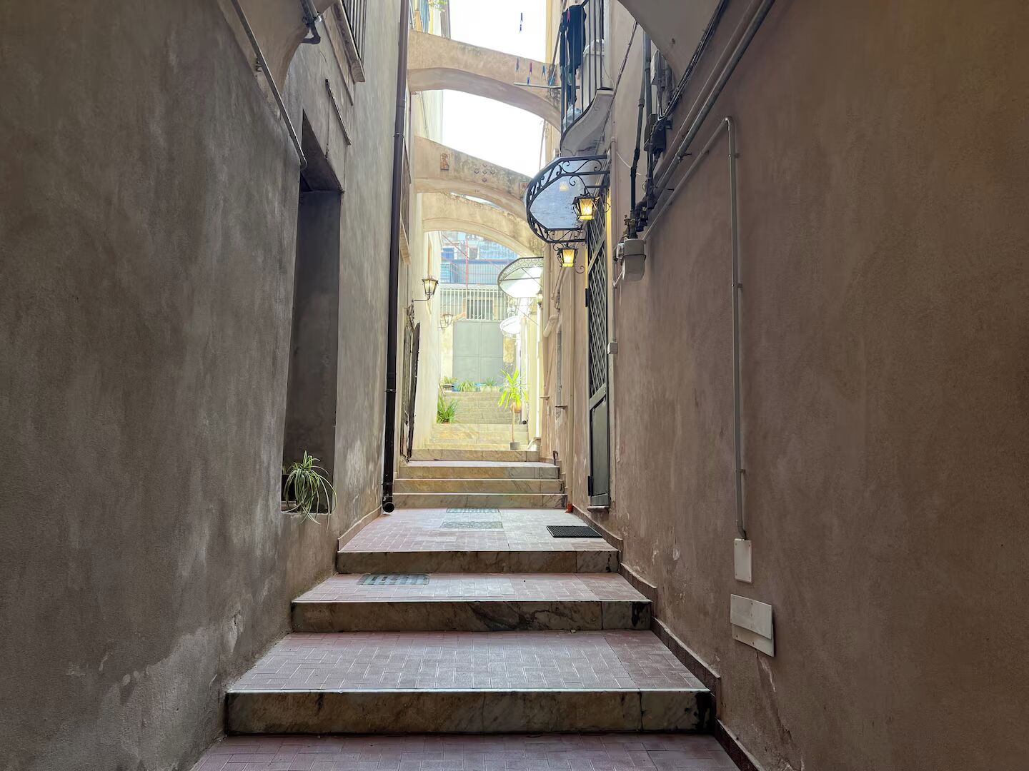 Un estrecho callejón con una escalera que lleva a la entrada de un edificio.