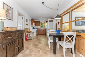 Una cocina con comedor, armarios de madera, un extintor y una ventana con vista.