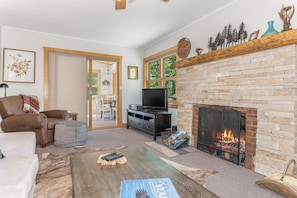 Una sala de estar con chimenea, televisor y sofá.