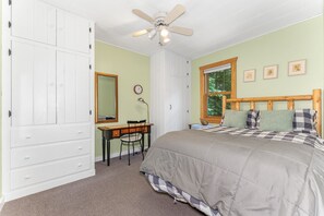 A bedroom with a bed, a desk with a chair, a ceiling fan, a window, and a clock on the wall. - Waterfront Minocqua Retreat with Lake Views (Minocqua)