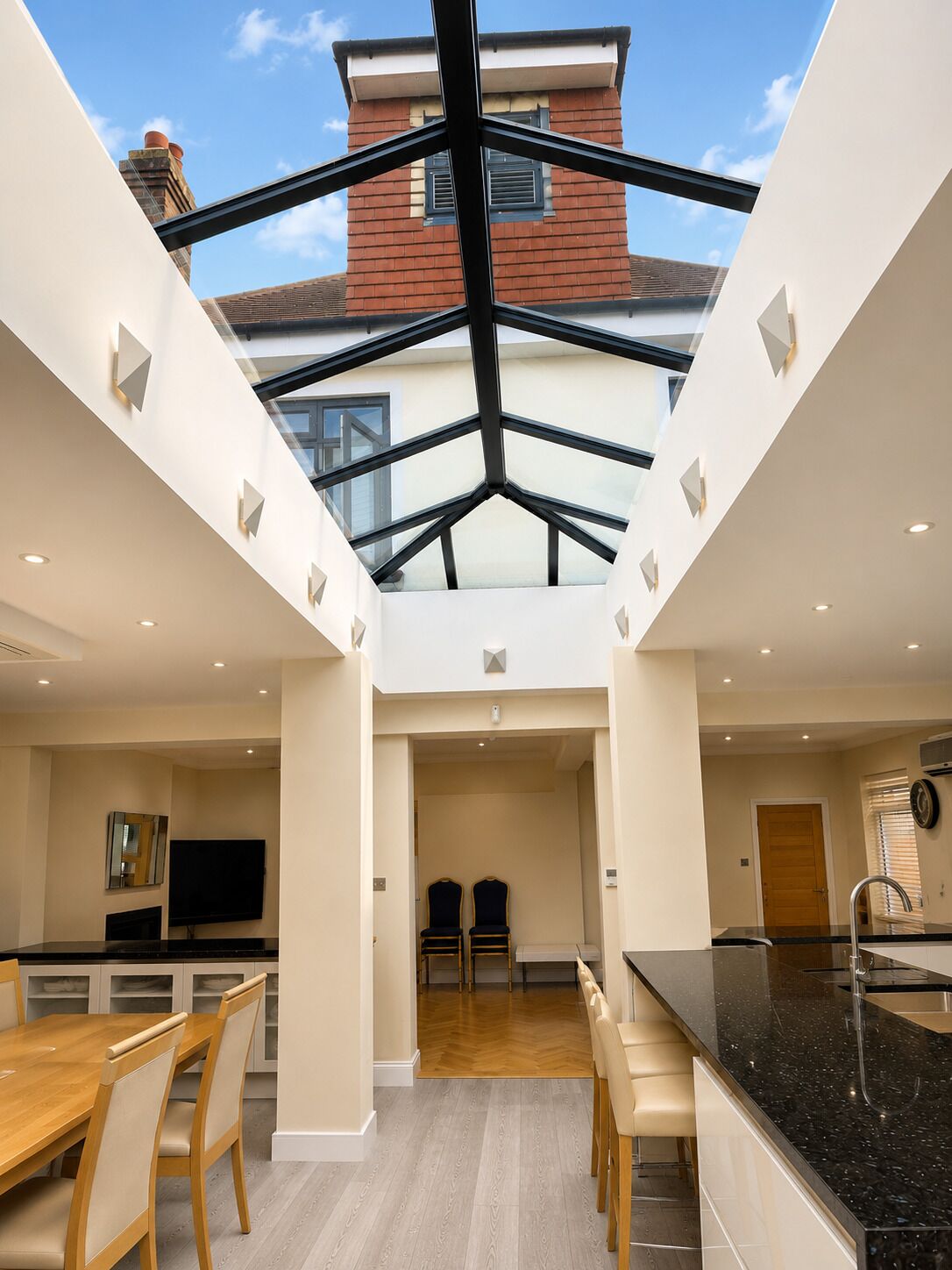 A modern interior with a central skylight, a dining area, and a kitchen.