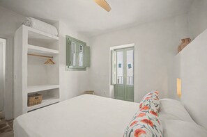 A bedroom with a bed, a wardrobe, a door, and a window. - Village House in the Town Center with Sea Views (Vejer de la Frontera)