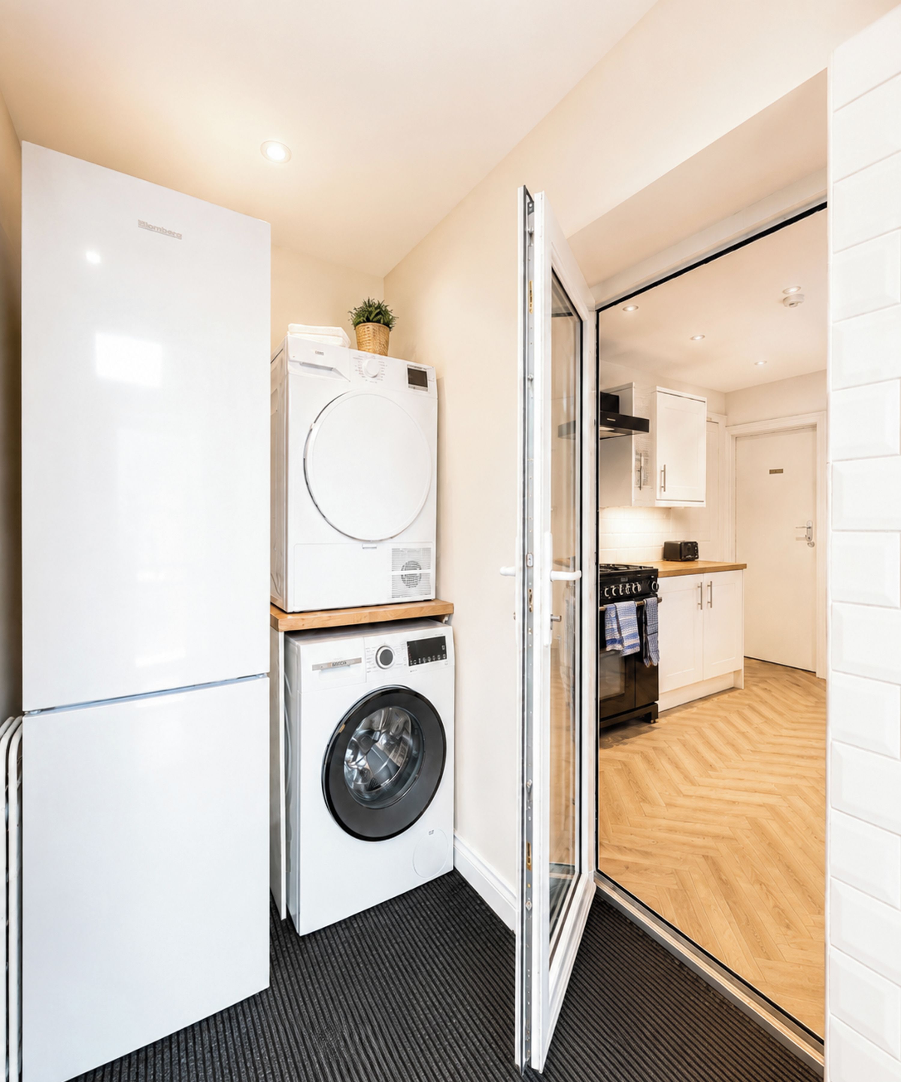A compact laundry area with a washing machine, dryer, and a small cabinet.