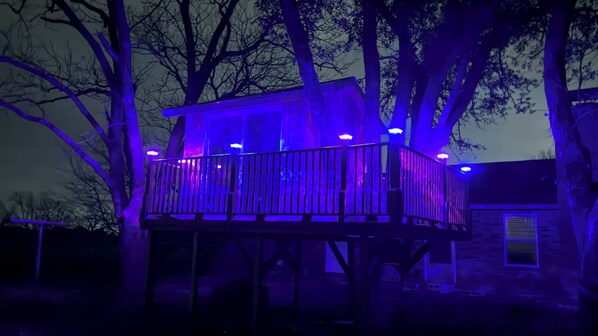 Una casa con terraza de madera y balcón.