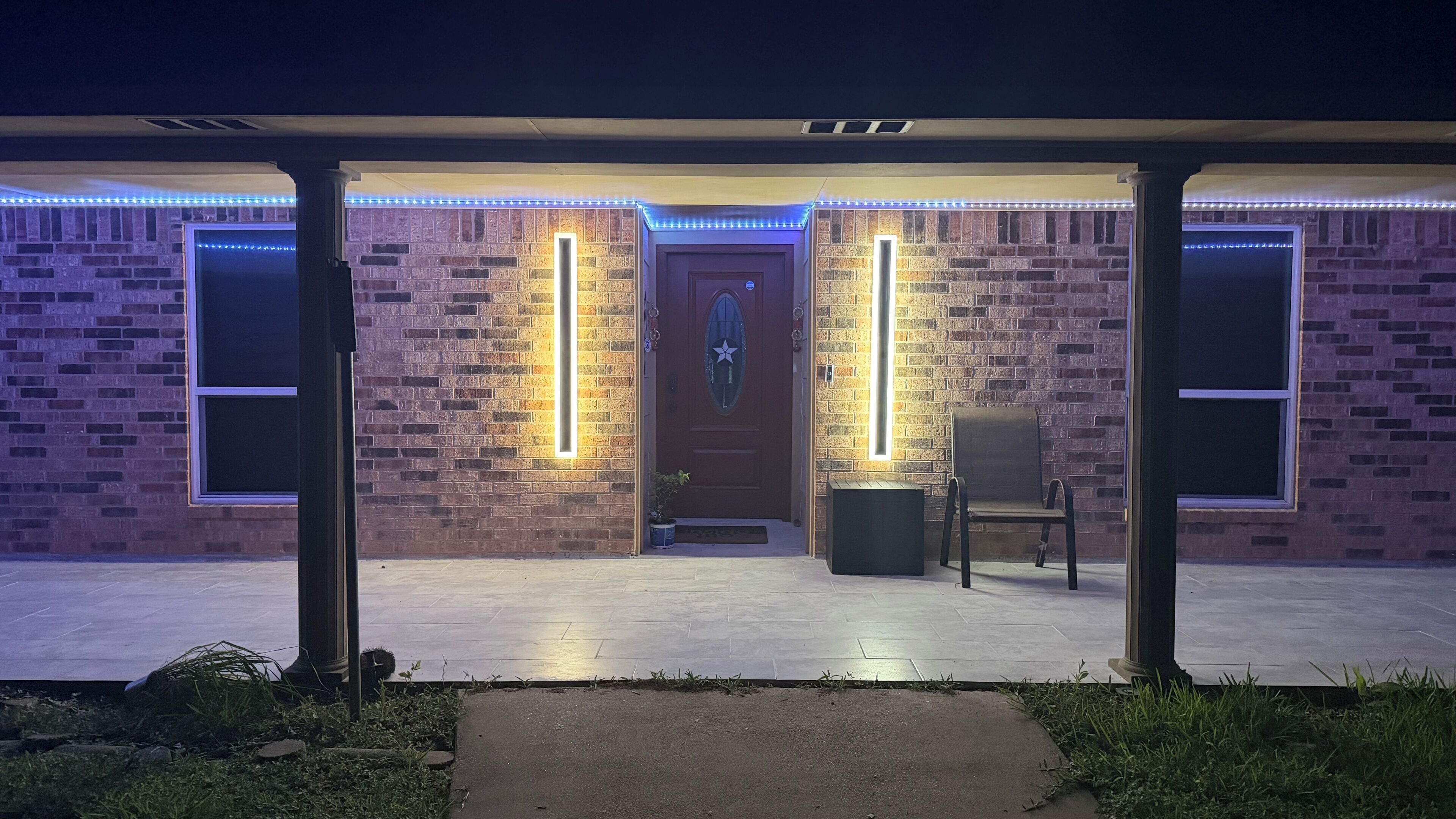 Un edificio con facciata in mattoni, una porta con finestra a forma di stella e strisce luminose verticali.