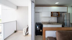 Una cucina moderna con mobili bianchi, un forno a microonde e un frigorifero.