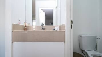 A bathroom with a toilet, bidet, and a mirror.