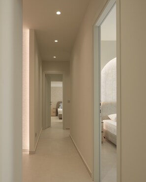 A hallway leading to a bedroom with a bed and a nightstand. - Infinity Suites 1, By Hellocrete (Rethymno)