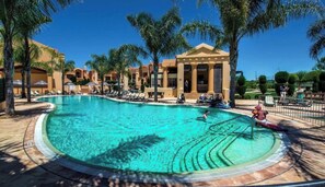 A resort pool with clear water, surrounded by palm trees and lounge chairs. - Luxurious 2-bedroom Apartment in Luz, Portugal (Lagos)
