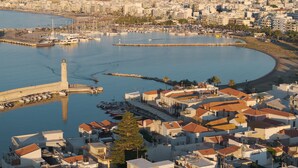 A coastal town with a marina, buildings with red-tiled roofs, and a lighthouse. - Infinity Suites 2, By Hellocrete (Rethymno)