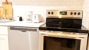 A kitchen with stainless steel appliances, including a microwave, oven, and dishwasher. - Comfortable English Appartment Walk to A Union Market (Washington)