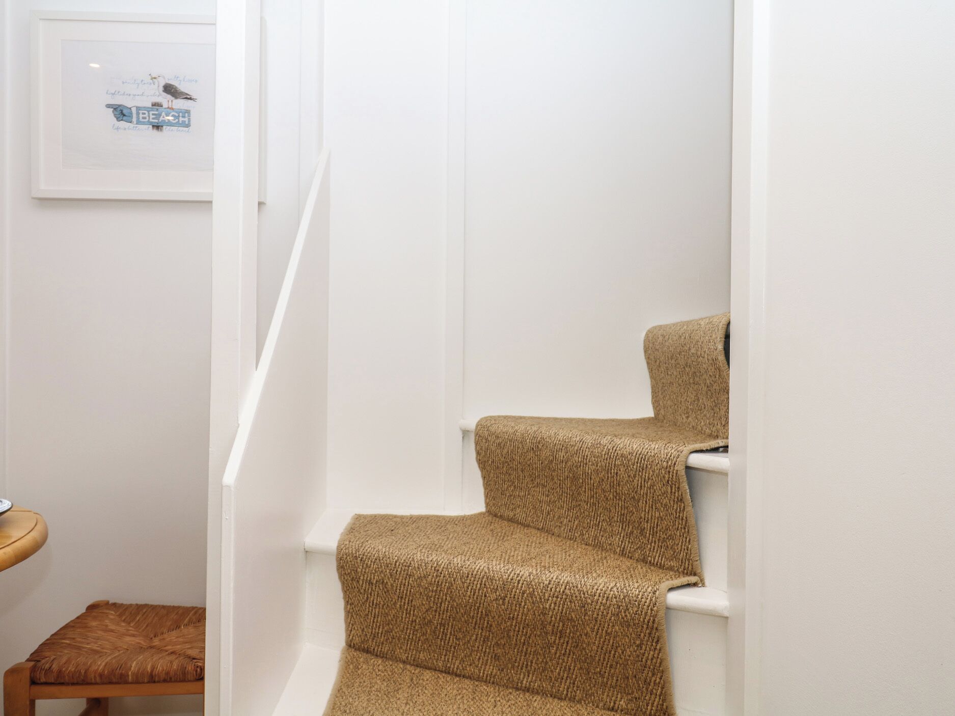 Una escalera con peldaños alfombrados y un cuadro en la pared.