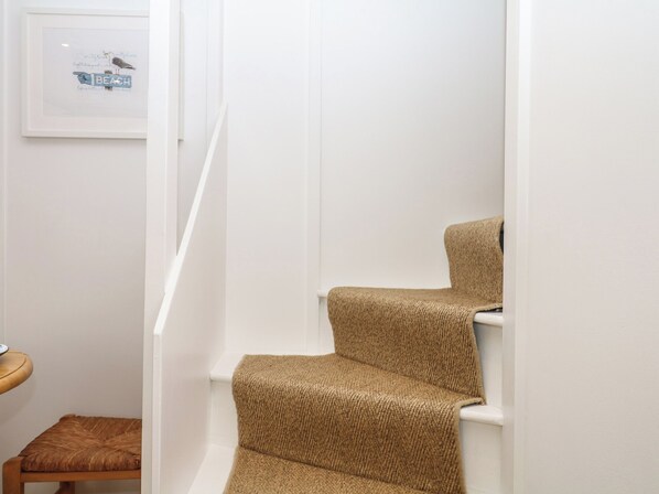 Una escalera con peldaños alfombrados y un cuadro en la pared.