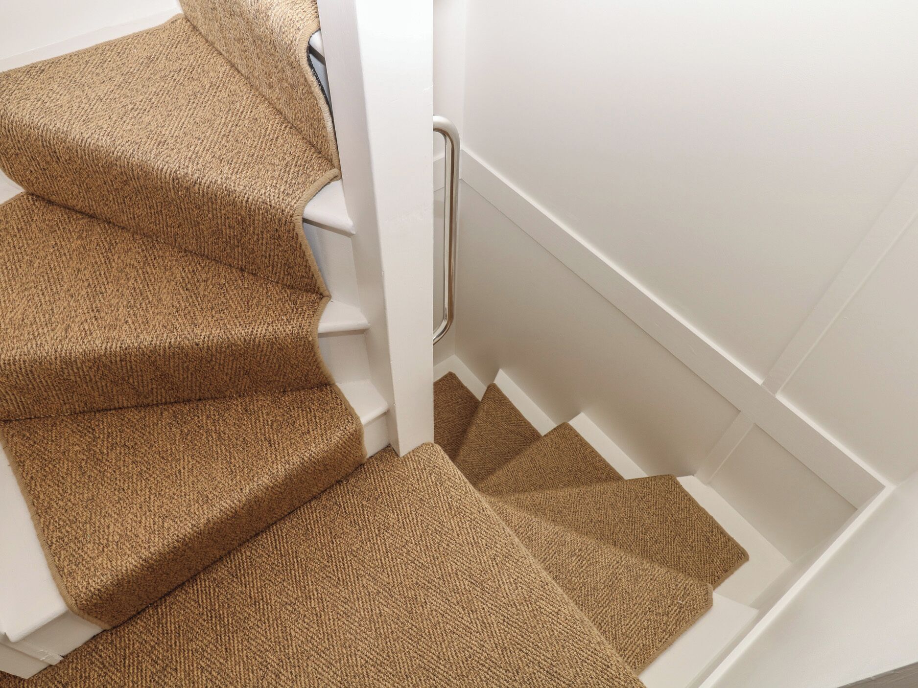 A staircase with carpeted steps and a white handrail.