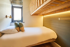 A single bed with a wooden headboard, a window with blinds, and a wall-mounted lamp. - Host Stay Casa Formentera (Scarborough)