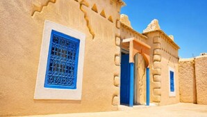 Een gebouw met een blauwe deur en een raam, met traditionele architectuur.