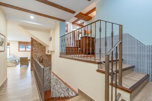 A staircase with wooden railings and a stone wall. - La Casona De Cuéllar: Rural House for Groups with Pool in Segovia (Cuéllar)