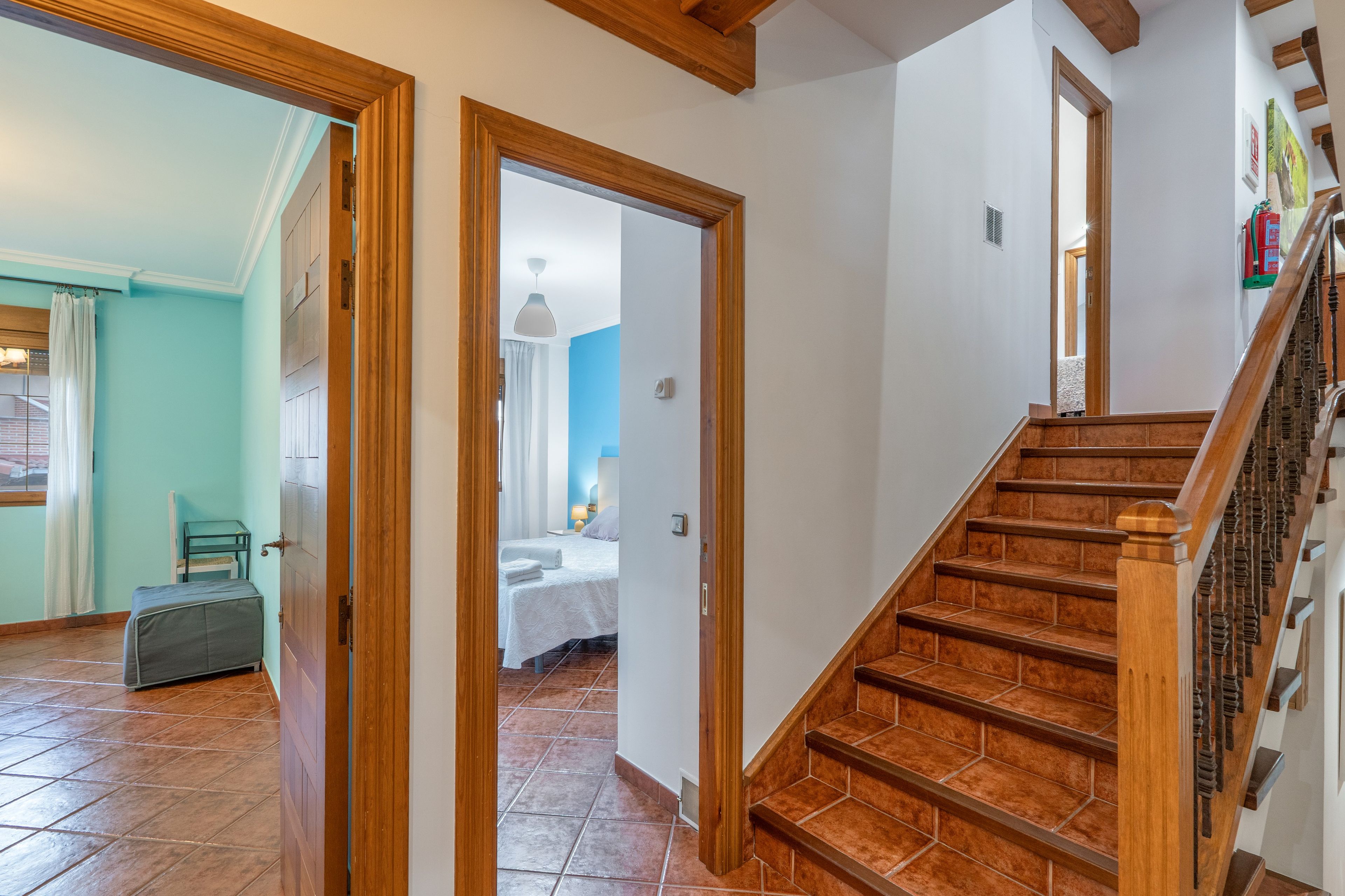 A staircase leading to a bedroom with a bed and a nightstand.