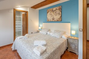 A bedroom with a large bed, a nightstand, a dresser, a mirror, and a wall with a map. - La Casona De Cuéllar: Rural House for Groups with Pool in Segovia (Cuéllar)