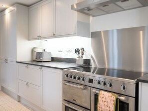 A modern kitchen with stainless steel appliances, white cabinetry, and a black countertop. - 23 Trafalgar Road (Scarborough)