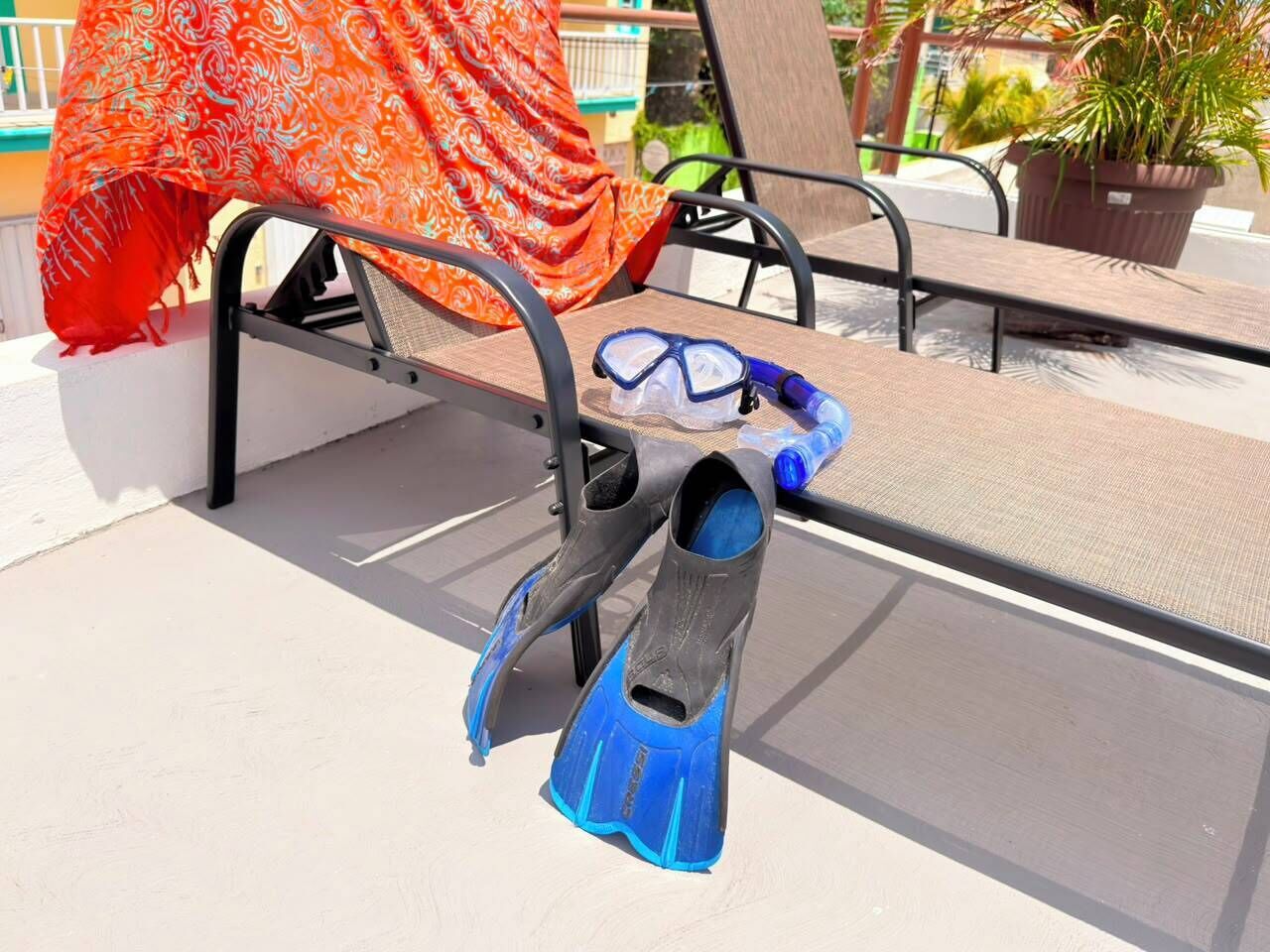 A pair of blue and black diving fins on a metal chair.