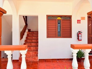 A staircase leading to a room with a fire extinguisher mounted on the wall. - Villas Kaab (Cozumel)