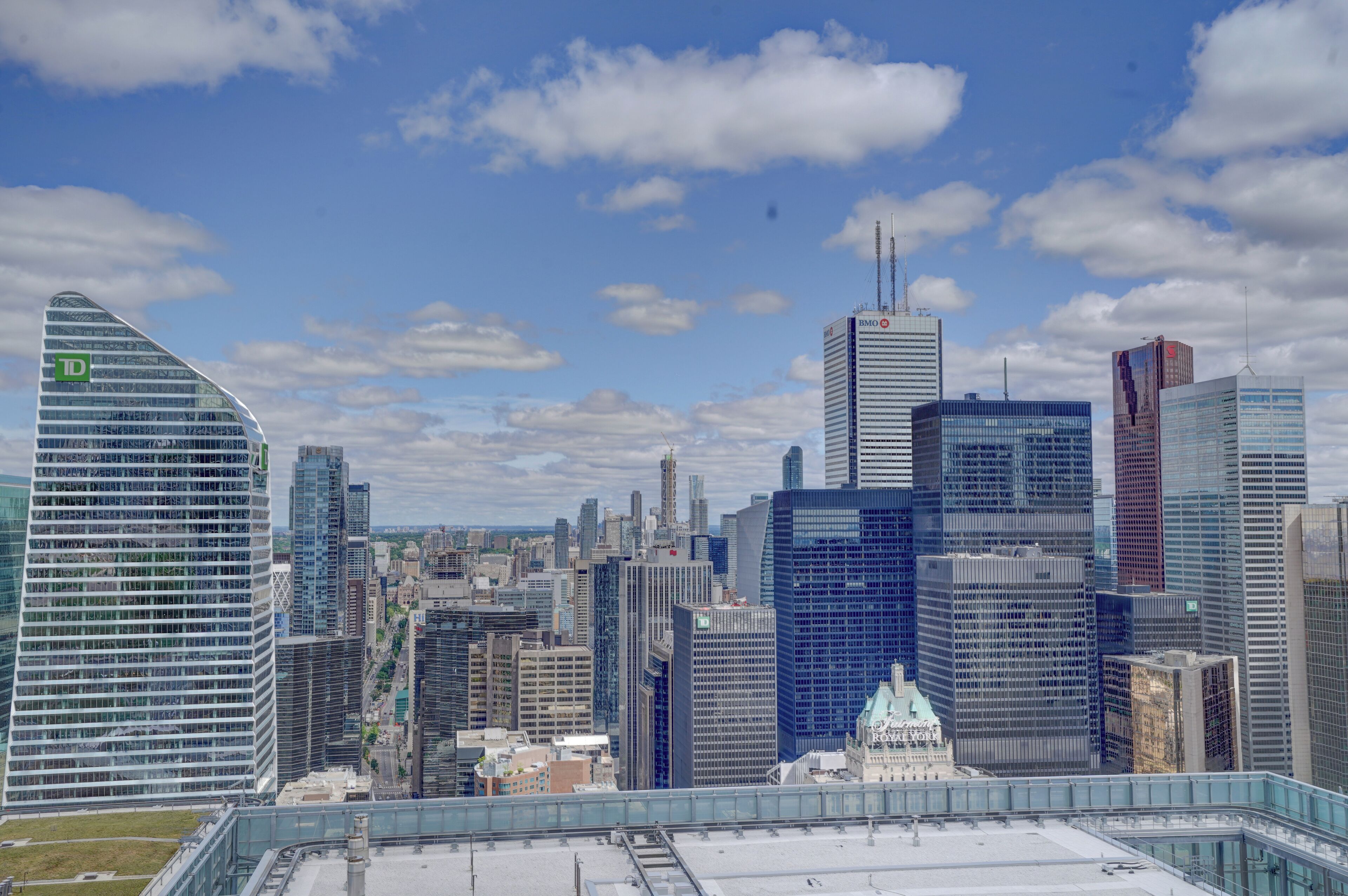 A cityscape with modern skyscrapers, including a prominent TD Bank building, and a historic building with a dome.