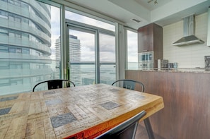 Cozinha moderna com uma janela ampla, uma mesa de jantar e vista para a paisagem urbana.