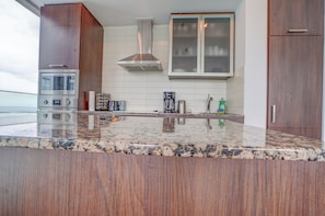 A modern kitchen with a stainless steel range, a built-in microwave, and a granite countertop.