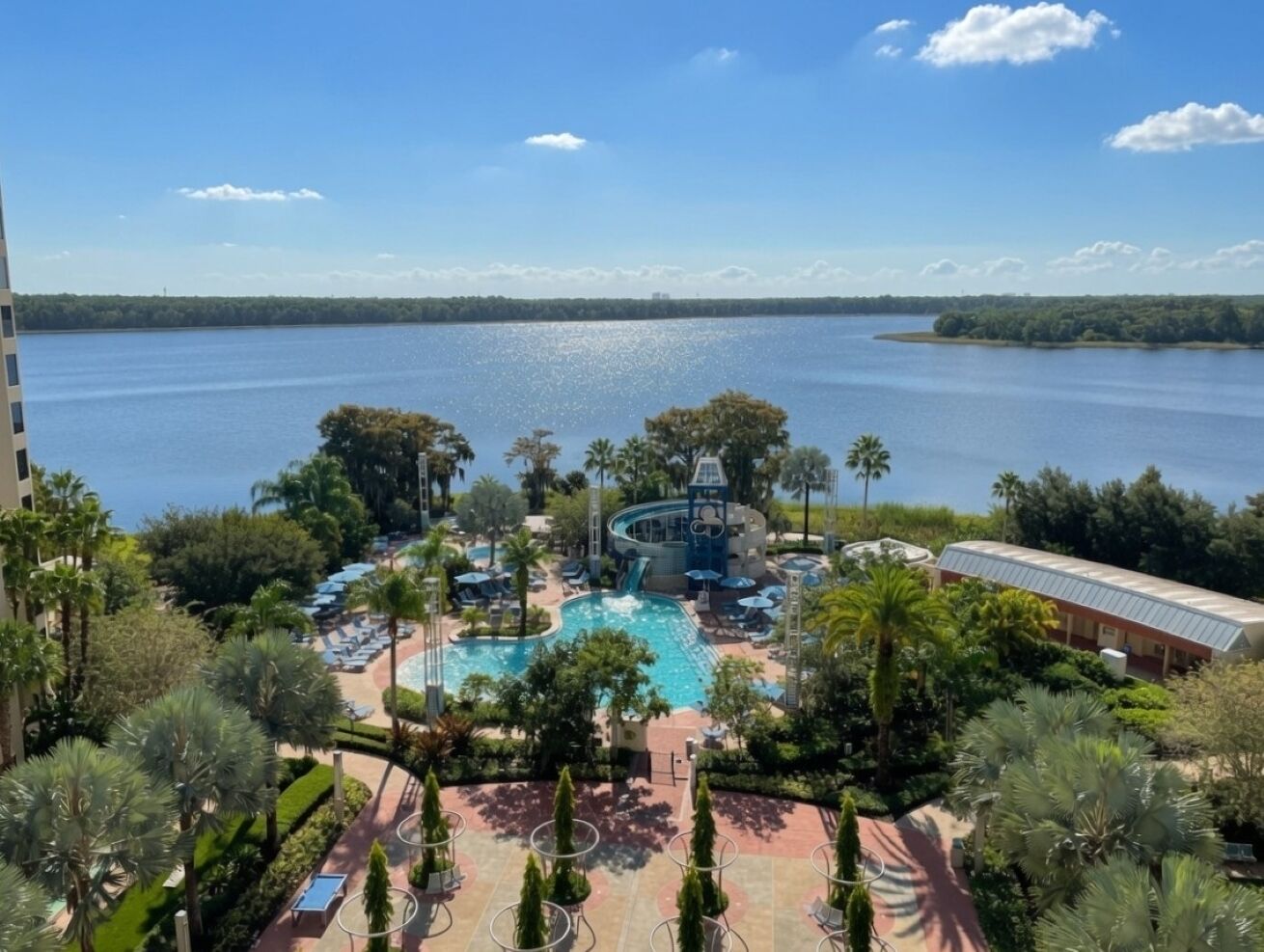 Ein Resort mit Swimmingpool, Liegestühlen und Blick auf das Wasser.