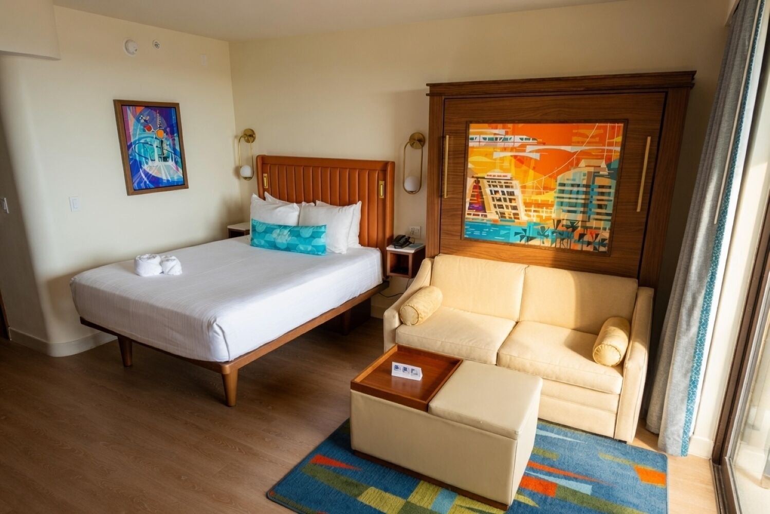 Ein Hotelzimmer mit Bett, einer Couch, einem Couchtisch und einem Bild an der Wand.