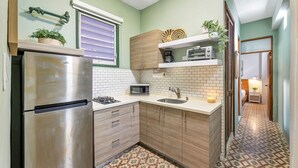 Eine kleine Küche mit Kühlschrank, Mikrowelle und Spüle.