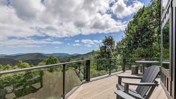 Eine Terrasse mit Gartenmöbeln mit Blick auf eine Berglandschaft.