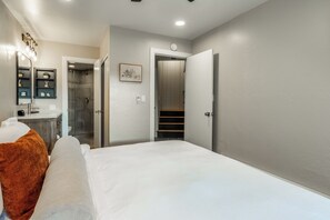 A bedroom with a bed, a nightstand, a mirror, a shower, and a door leading to a staircase. - Spacious 2BR + Loft Mammoth Escape 680 (Mammoth Lakes)