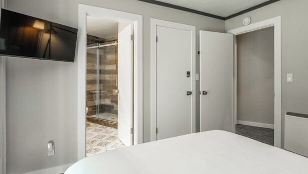 Een slaapkamer met een bed, inloopkast en een douche.