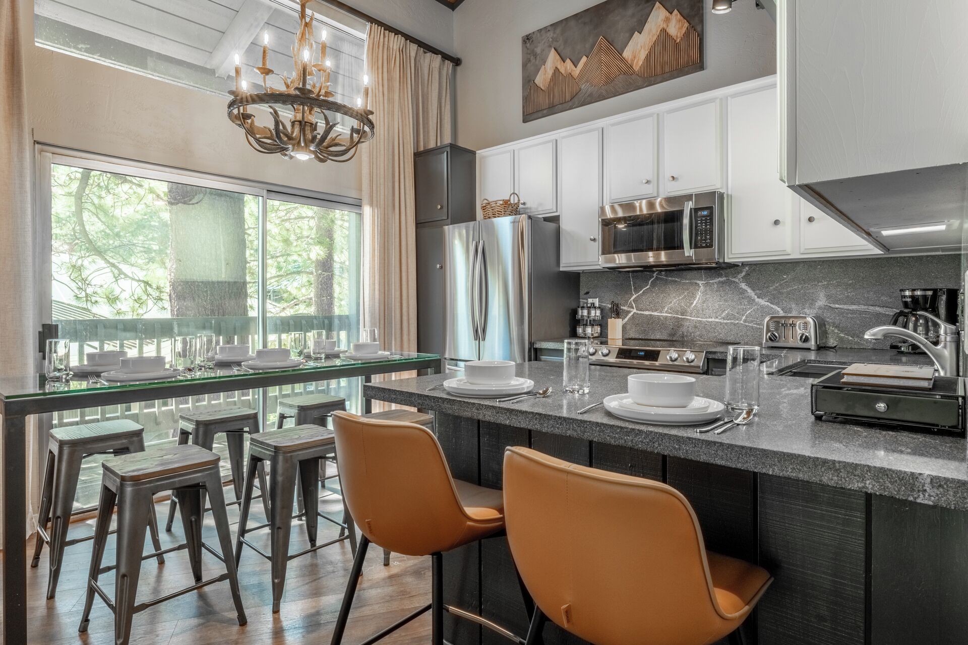 Una cocina moderna con una isla grande, electrodomésticos de acero inoxidable y vistas al exterior.