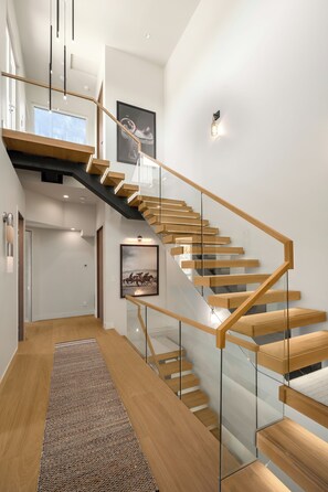 A modern staircase with glass railings and wooden steps, leading to a second floor. - Close to Gondola Townhome 1097 (Steamboat Springs)