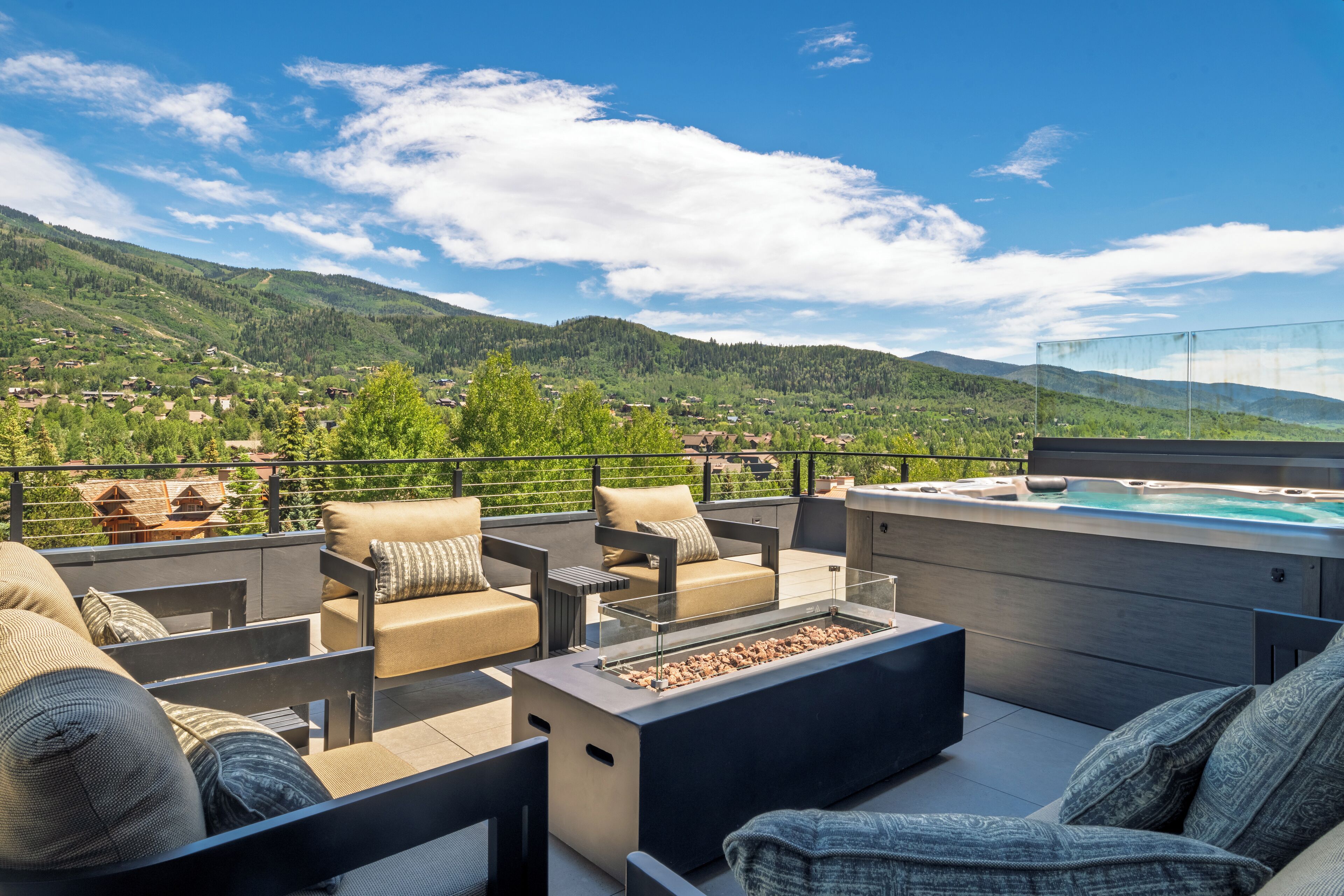 Eine Dachterrasse mit Gartenmöbeln, einem Whirlpool und einem herrlichen Bergblick.