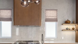 A modern kitchen with a central island, stainless steel appliances, and pendant lighting. - Close to Ski Townhome 1096 (Steamboat Springs)