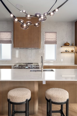 A modern kitchen with a central island, stainless steel appliances, and pendant lighting. - Close to Ski Townhome 1096 (Steamboat Springs)