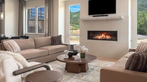 A modern living room with a beige sofa, a round coffee table, and a fireplace. - Close to Ski Townhome 1096 (Steamboat Springs)