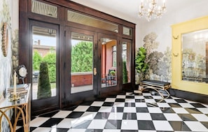 A room with a checkered floor, a bench, a mirror, and a door with glass panels. - Historic 1910 Pittsburgh Victorian  (Pittsburgh)