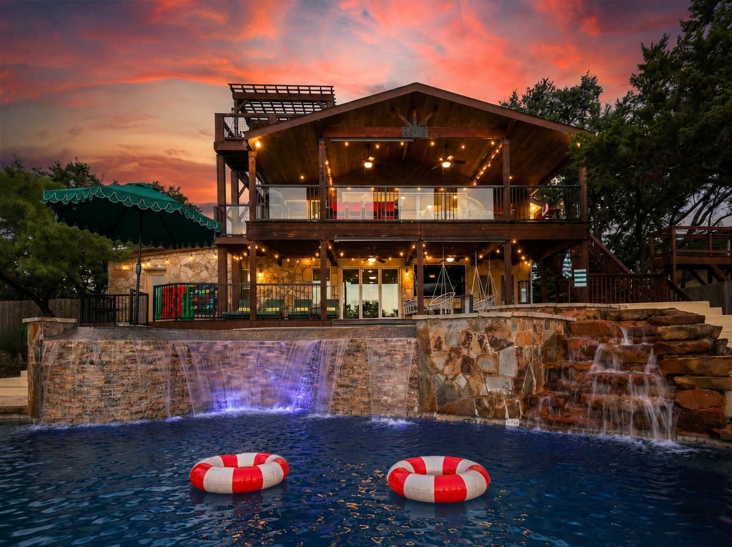 A two-story building with a pool, outdoor seating, and a waterfall feature.