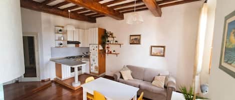 Un espacio de sala acogedor con comedor, cocina y un sofá.