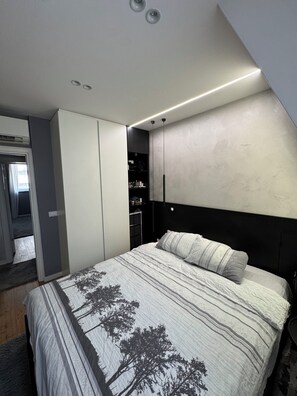 A bedroom with a bed, a wardrobe, and a built-in shelf unit. - 2BR Skopje Apartment with Cathedral View, In The Main Square (Skopje)