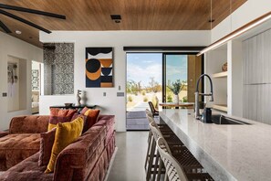 Un intérieur moderne comprenant un canapé, un coin repas et une cuisine.